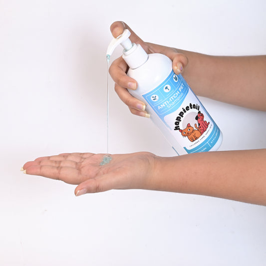 Hand holding a bottle of HappieTail Anti-Itch pet shampoo over another hand on a white background