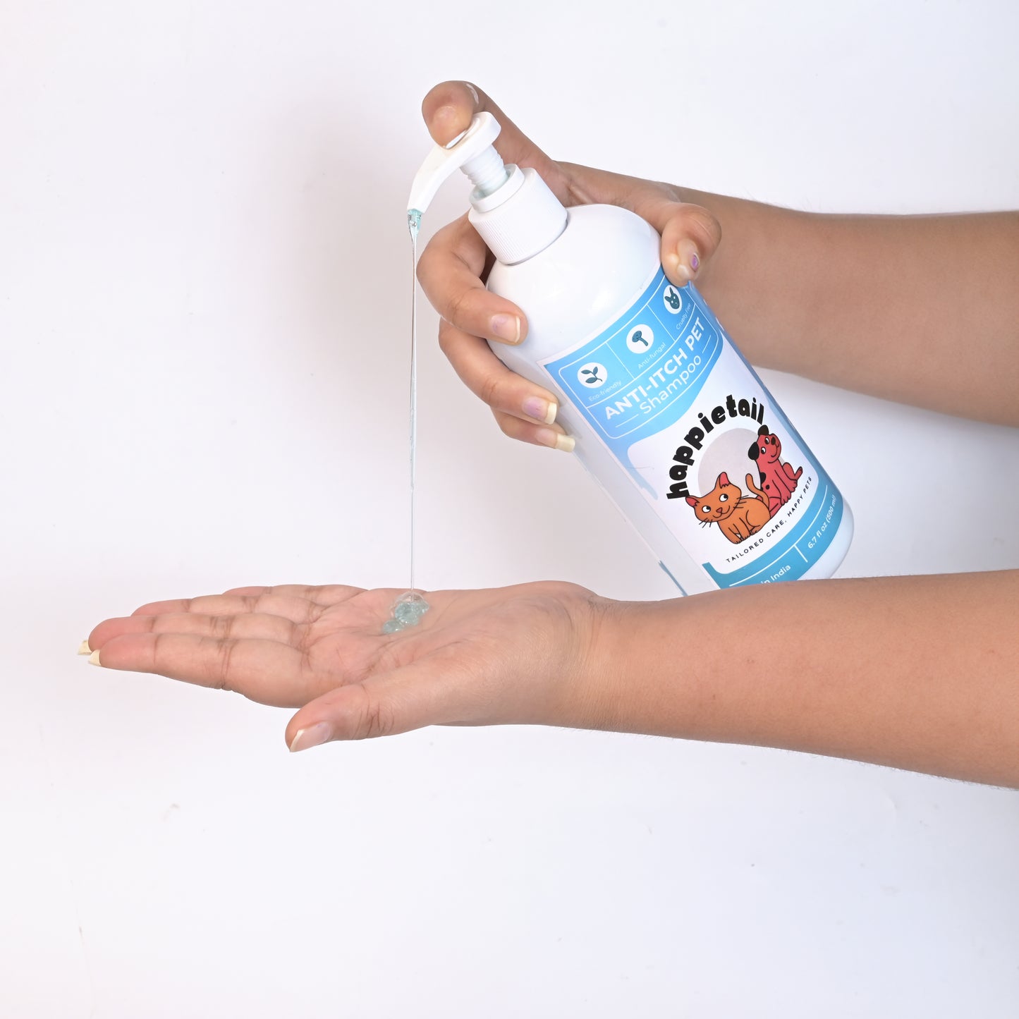 Hand holding a bottle of HappieTail Anti-Itch pet shampoo over another hand on a white background